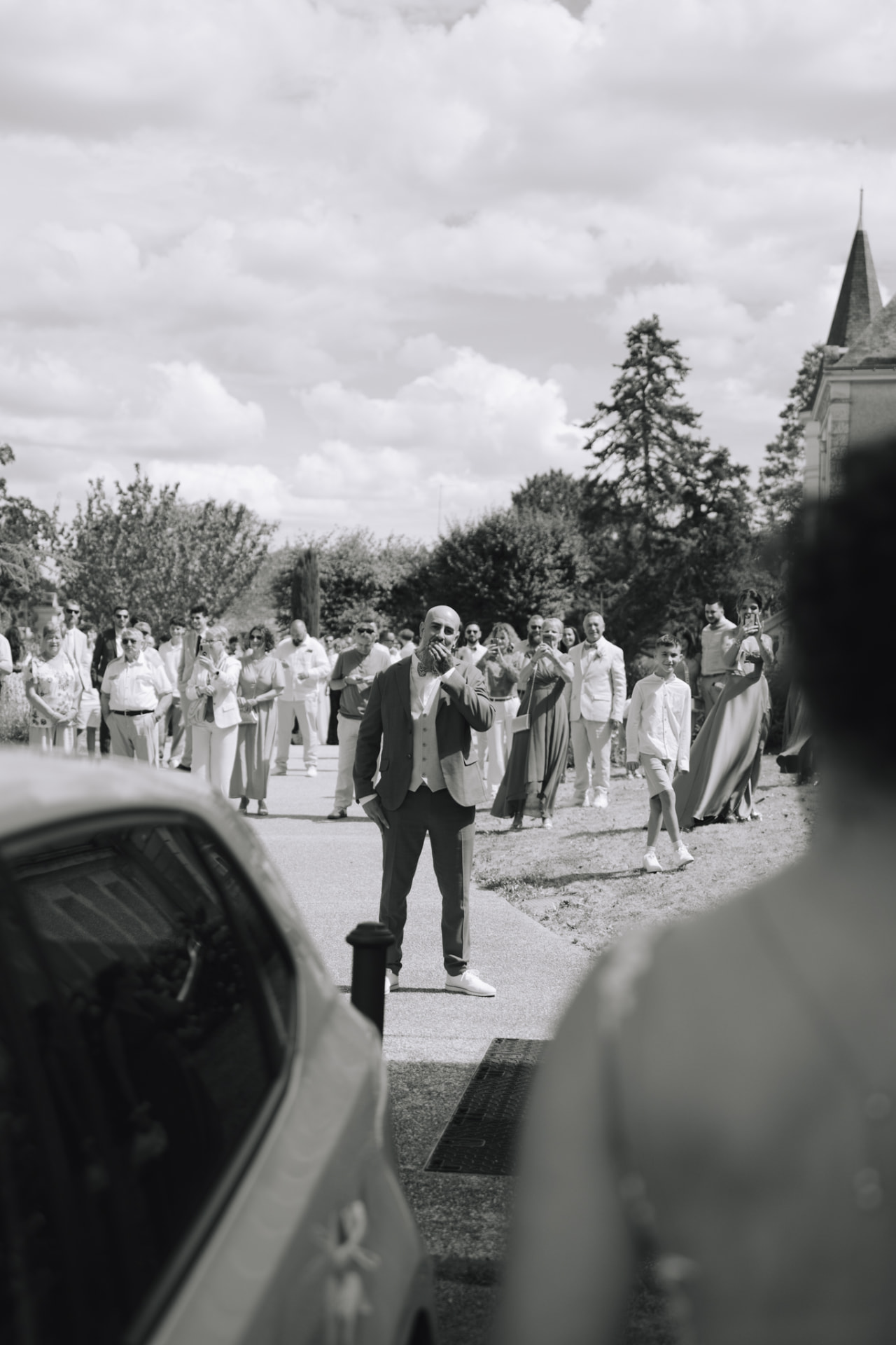 Le marié découvre la mariée devant les invités réunis, en noir et blanc